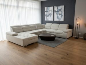 Canapé d'angle beige moderne, table basse sombre et tapis gris sur parquet dans un salon élégant.