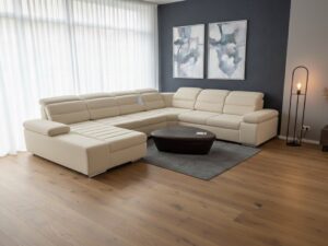 Grand canapé d'angle beige en U dans un salon moderne avec parquet, table basse en bois et mur bleu.