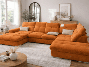 Canapé panoramique en velours côtelé orange dans un salon lumineux avec tapis texturé et table ronde en bois.