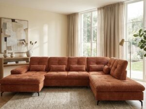 Canapé panoramique en velours côtelé rouille dans un salon moderne et lumineux aux tons naturels.