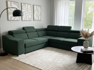 Canapé d'angle vert forêt dans un salon moderne avec tapis géométrique, lampadaire noir et tableaux abstraits.