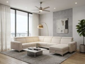 Salon moderne avec grand canapé d'angle crème, table basse en marbre, luminaire doré et plante verte.