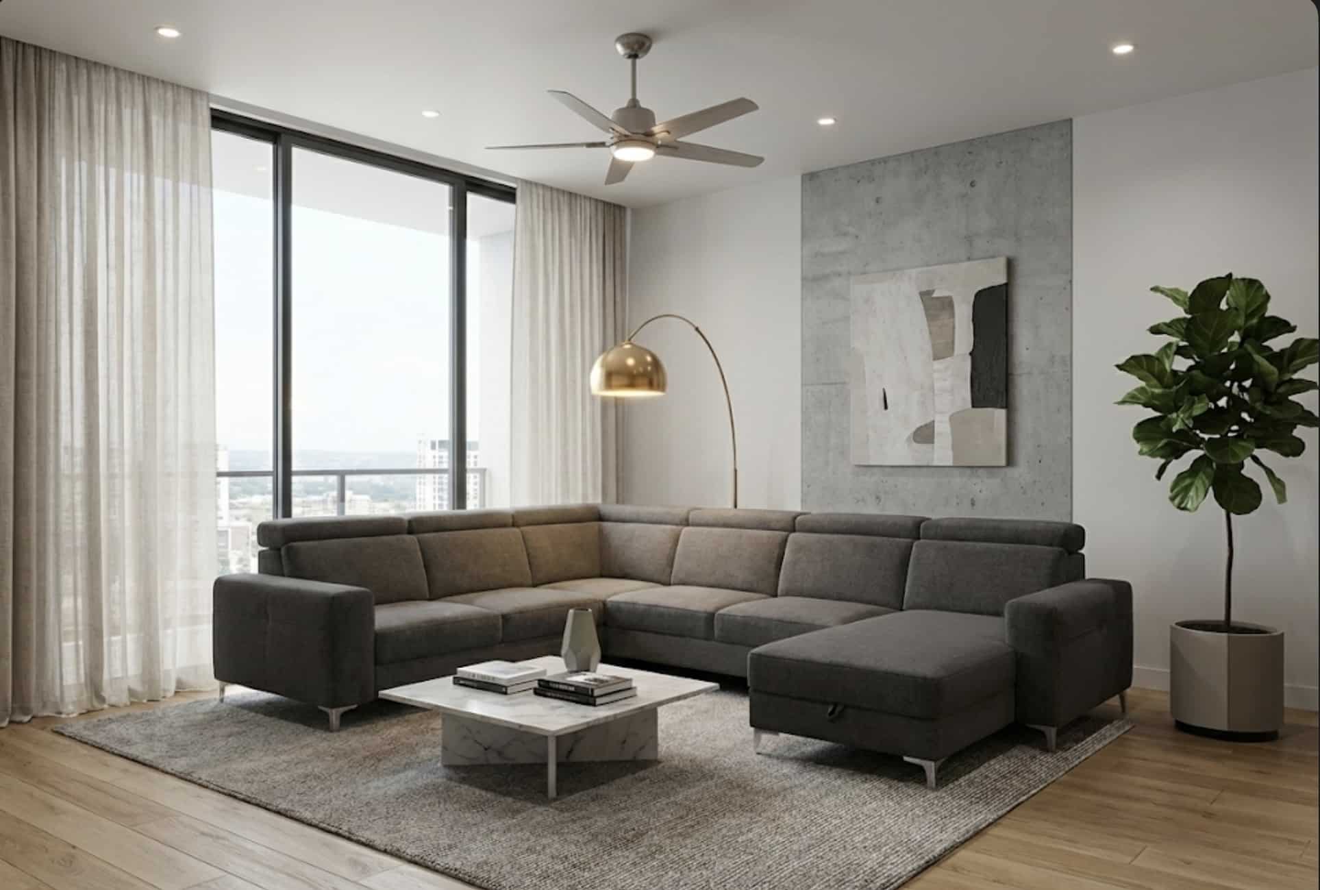 Salon moderne avec canapé d'angle gris, table basse en marbre, lampe dorée et plante verte devant une grande baie vitrée.